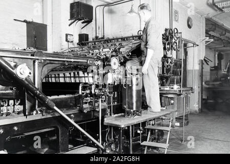 Ein Arbeiter kontrolliert mourir dans Rotationsdruckmaschine Maschinenbaukonzerns den Werken des MAN (Maschinenfabrik Augsburg-Nürnberg), Deutschland 1930 er Jahre. Un travailleur le contrôle de la presse d'impression rotative dans les usines de la société d'ingénierie mécanique (homme), Maschinenfabrik Augsburg-Nürnberg Allemagne 1930. Banque D'Images