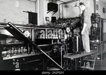 Ein Arbeiter kontrolliert mourir dans Rotationsdruckmaschine Maschinenbaukonzerns den Werken des MAN (Maschinenfabrik Augsburg-Nürnberg), Deutschland 1930 er Jahre. Un travailleur le contrôle de la presse d'impression rotative dans les usines de la société d'ingénierie mécanique (homme), Maschinenfabrik Augsburg-Nürnberg Allemagne 1930. Banque D'Images