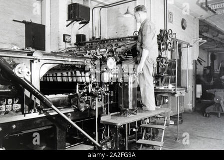 Ein Arbeiter kontrolliert mourir dans Rotationsdruckmaschine Maschinenbaukonzerns den Werken des MAN (Maschinenfabrik Augsburg-Nürnberg), Deutschland 1930 er Jahre. Un travailleur le contrôle de la presse d'impression rotative dans les usines de la société d'ingénierie mécanique (homme), Maschinenfabrik Augsburg-Nürnberg Allemagne 1930. Banque D'Images