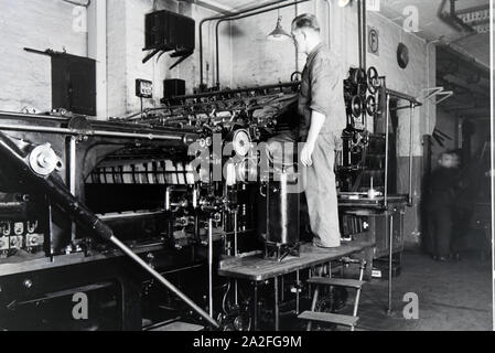 Ein Arbeiter kontrolliert mourir dans Rotationsdruckmaschine Maschinenbaukonzerns den Werken des MAN (Maschinenfabrik Augsburg-Nürnberg), Deutschland 1930 er Jahre. Un travailleur le contrôle de la presse d'impression rotative dans les usines de la société d'ingénierie mécanique (homme), Maschinenfabrik Augsburg-Nürnberg Allemagne 1930. Banque D'Images