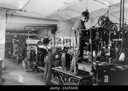 Druckereimitarbeiter bei der Arbeit an der Rotationsdruckmaschine Maschinenbaukonzerns in den Werken des MAN (Maschinenfabrik Augsburg-Nürnberg), Deutschland 1930 er Jahre. Les travailleurs de l'imprimerie sur la presse d'impression rotative dans les usines de la société d'ingénierie mécanique (homme), Maschinenfabrik Augsburg-Nürnberg Allemagne 1930. Banque D'Images