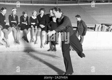 Eiskunstläufer Olympiasieger und der Karl Schäfer beim Training von der Gruppe Hitlerjugend einem Dortmunder Eisstadion, Deutschland 1930er Jahre. Le figureskater et champion olympique autrichien Karl Schäfer lors d'une formation d'un groupe de membres de la jeunesse hitlérienne dans un stade de glace à Dortmund, Allemagne, 1930. Banque D'Images