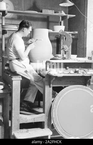 Ein der Staatlichen Porzellanmanufaktur Keramiker Berlin bei der Arbeit mit großen un vase, Deutschland 1930 er Jahre. Un céramiste de la Manufacture de Porcelaine d'État de Berlin sur un grand vase, Allemagne 1930. Banque D'Images