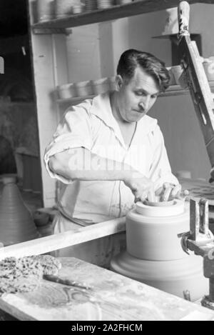 Ein Töpfer der Staatlichen Porzellanmanufaktur Berlin bei der Arbeit an der Töpferscheibe, 1930er Jahre Deutschland. Un potter, de l'État Manufacture de Porcelaine de Berlin sur la roue de la poterie, de l'Allemagne des années 1930. Banque D'Images