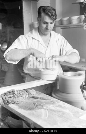 Ein Töpfer der Staatlichen Porzellanmanufaktur Berlin bei der Arbeit an der Töpferscheibe, 1930er Jahre Deutschland. Un potter, de l'État Manufacture de Porcelaine de Berlin sur la roue de la poterie, de l'Allemagne des années 1930. Banque D'Images