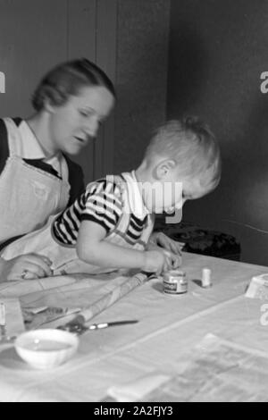 Mutter und genre beim basteln, Deutschland 1930 er Jahre. La mère et l'enfant de faire de l'artisanat, de l'Allemagne des années 1930. Banque D'Images