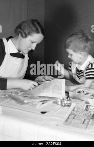 Mutter und genre beim basteln, Deutschland 1930 er Jahre. La mère et l'enfant de faire de l'artisanat, de l'Allemagne des années 1930. Banque D'Images