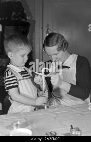 Mutter und genre beim basteln, Deutschland 1930 er Jahre. La mère et l'enfant de faire de l'artisanat, de l'Allemagne des années 1930. Banque D'Images