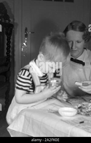 Mutter und genre beim basteln, Deutschland 1930 er Jahre. La mère et l'enfant de faire de l'artisanat, de l'Allemagne des années 1930. Banque D'Images