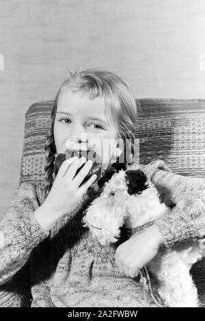 Ein Mädchen isst Liegnitzer Bomben, Deutsches Reich 1930er Jahre. Un girl eating Liegnitzer Bomben, Allemagne 1930. Banque D'Images