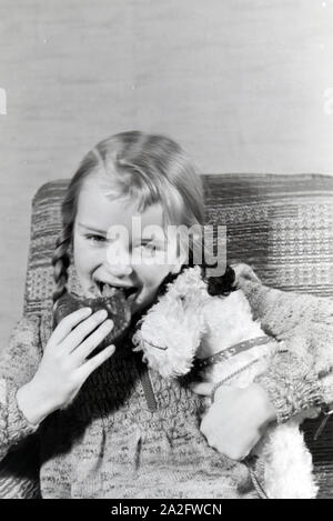 Ein Mädchen isst Liegnitzer Bomben, Deutsches Reich 1930er Jahre. Un girl eating Liegnitzer Bomben, Allemagne 1930. Banque D'Images