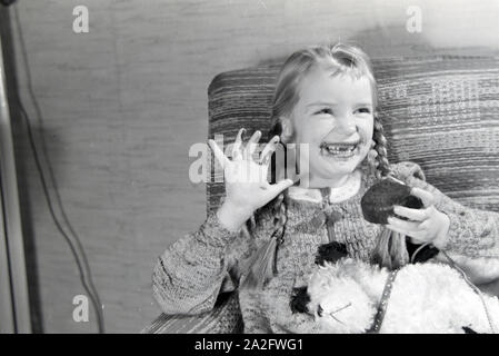 Ein Mädchen isst Liegnitzer Bomben, Deutsches Reich 1930er Jahre. Un girl eating Liegnitzer Bomben, Allemagne 1930. Banque D'Images