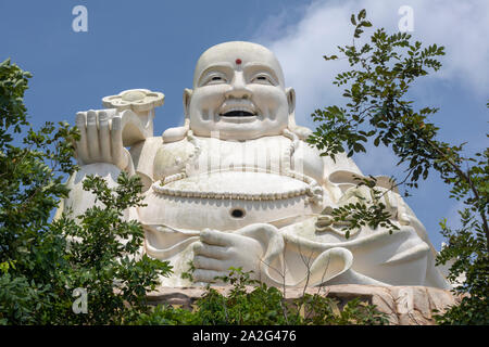 Gros plan d'un souriant blanc Bouddha assis dans le haut des arbres, Vang Tau, Vietnam Banque D'Images