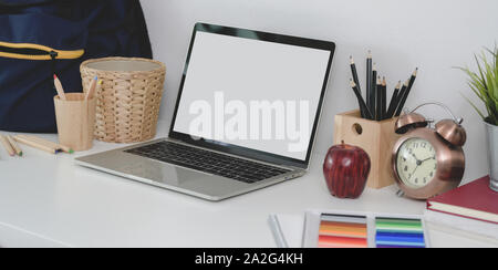 Cropped shot de travail confortable avec un ordinateur portable avec écran vide à l'arrêt et sac d'école Banque D'Images