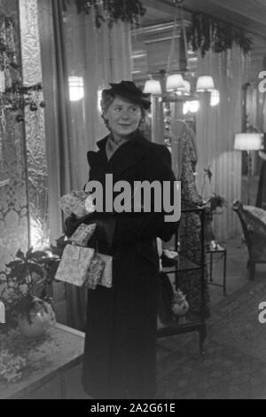 Eine Frau bei einem dans Weihnachtseinkäufen Kaufhaus, Deutschland 1930 er Jahre. Une femme faire son shopping de Noël dans un departement store, Allemagne 1930. Banque D'Images