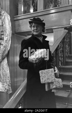 Eine Frau bei einem dans Weihnachtseinkäufen Kaufhaus, Deutschland 1930 er Jahre. Une femme faire son shopping de Noël dans un departement store, Allemagne 1930. Banque D'Images