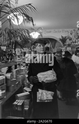 Eine Frau bei einem dans Weihnachtseinkäufen Kaufhaus, Deutschland 1930 er Jahre. Une femme faire son shopping de Noël dans un departement store, Allemagne 1930. Banque D'Images