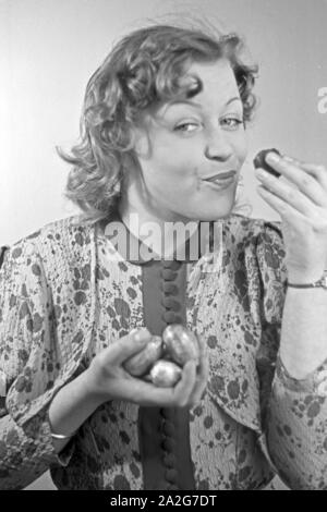 Porträt eines jungen Mädchens, Schokoladenostereier essend, 1930er Jahre Deutschland. Portrait d'une jeune fille de manger des oeufs de pâques en chocolat, Allemagne 1930. Banque D'Images