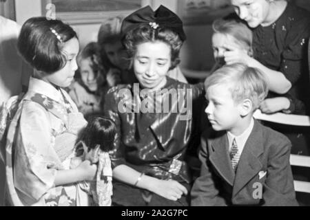 Japanische und Deutsche Kinder treffen sich bei einer Ausstellung der Reichsfrauenführung, Deutschland 1930 er Jahre. Les enfants allemands et japonais de se rencontrer lors d'une exposition de l'Reichsfrauenfuehrung, l'organisation de la femme, de l'Allemagne nazie des années 1930. Banque D'Images