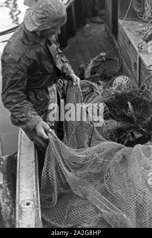 Ein Fischer bereitet die Netze zum vor der Fischfang dans Ostsee, Deutschland 1930 er Jahre. Un pêcheur préparer les filets pour la pêche en mer Baltique, Allemagne 1930. Banque D'Images