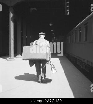 Gepäckträger auf dem Bahnsteig am Bahnhof in Hamburg, Deutschland 1930er Jahre. Porter des bagages à une plate-forme de la gare centrale de Hambourg, Allemagne 1930. Banque D'Images