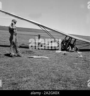 Ein Angestellter der Wasserkuppe Reichssegelflugschule unertsuchen abgestürztes bei Fulda ein Segelflugzeug, Deutschland 1930 er Jahre. Un membre du personnel de l'Reichssegelflugschule pour vol à voile Wasserkuppe près de Fulda l'examen de l'épave d'un avion, l'Allemagne des années 1930. Banque D'Images