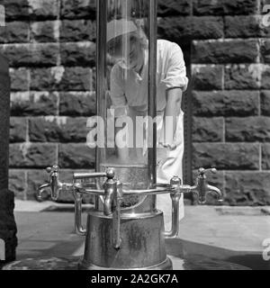 Eine Krankenschwester Kurbad im Bad Homburg von une Heilwasserquelle, 1930er Jahre Deutschland. Une infirmière sur un puits d'eau de guérison à Bad Homburg spa resort, Allemagne 1930. Banque D'Images