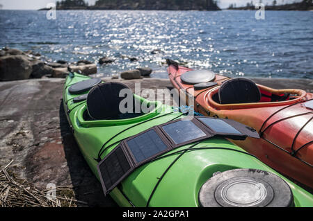 Les panneaux solaires portables sont sur le kayak qui se dressent sur la rive du lac et d'accumuler de l'énergie. Banque D'Images