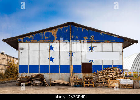 Close-up du drapeau national du Honduras peint sur la paroi métallique de l'entrepôt d'un grand territoire fermé un jour d'été. Le concept d'espace de stockage Banque D'Images