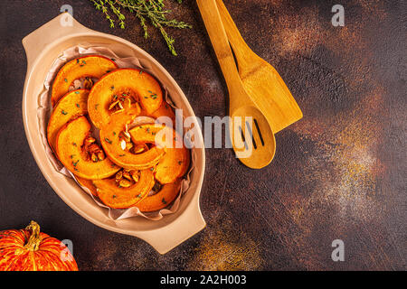 Tranches de citrouille cuite sur un fond sombre, vue d'en haut. Banque D'Images