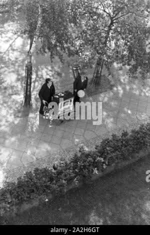 Ein-Mann-Kapelle spielt mit Leierkastenmann im Hof, Deutschland 1930 er Jahre. One-man-band et d'orgue de barbarie à jouer à la cour, l'Allemagne des années 1930. Banque D'Images