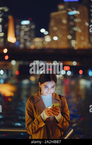 Jeune fille brune debout dans la nuit, par horizon de Chicago Banque D'Images