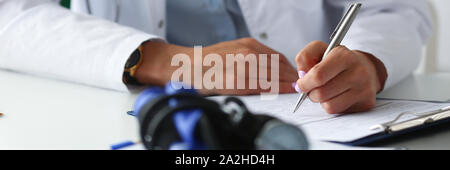 Femme médecin part écrire stylo argent papier d'ordonnance Banque D'Images