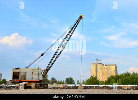 De grandes grues sur chenilles pelle à benne traînante ou avec un métal lourd boulet sur un câble en acier. Wrecking balles sur les chantiers de construction. Démontage et dem Banque D'Images
