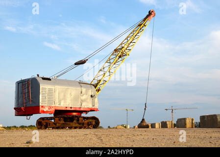 De grandes grues sur chenilles pelle à benne traînante ou avec un métal lourd boulet sur un câble en acier. Wrecking balles sur les chantiers de construction. Démontage et dem Banque D'Images