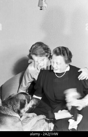 Die Prinzessin der Fastnacht à Mayence, Hildegard Kühne im Jahre 1938, zum hundertjährigen Jubiläum des Mainzer Carneval Verein (MCV) zuhause à Nieder-Olm mit ihrer Mutter und ihrem Hund. La princesse de carnaval à Mayence en 1938, à l'occasion du 100e anniversaire de l'association carnaval local de premier plan, à la maison avec sa mère et son chien à Nieder-Olm. Banque D'Images