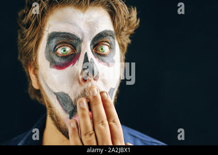 Homme masqué du jour de la mort à l'Halloween, regard étonné Banque D'Images