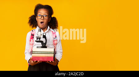 African American Elementary Student microscope comptable et pile de livres Banque D'Images