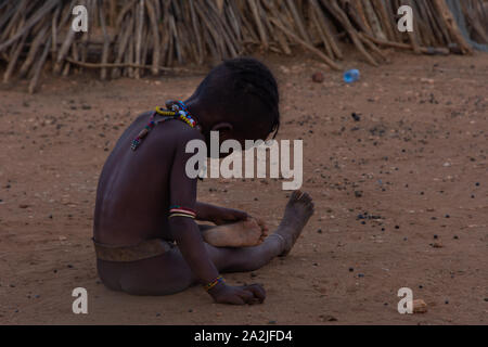 Turmi, Éthiopie - Nov 2018 : jeune tribu Hamer kid jouer à côté de la maison, vallée de l'Omo Banque D'Images