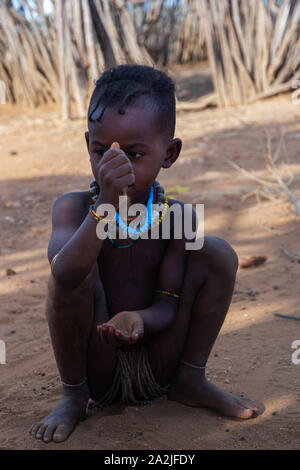 Turmi, Éthiopie - Nov 2018 : jeune tribu Hamer kid jouer à côté de la maison, vallée de l'Omo Banque D'Images