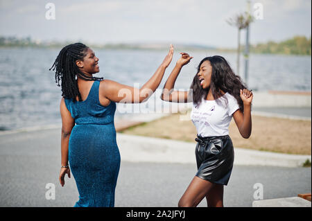 Deux pays africains-américains amis teint foncé femelle. L'un d'entre eux, second modèle taille plus mince. S'amuser et passer du temps ensemble. Donner une haute cinq chacun Banque D'Images