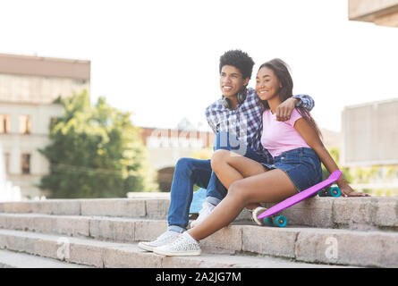 Couple of teenagers sitting on stairs outdoors Banque D'Images