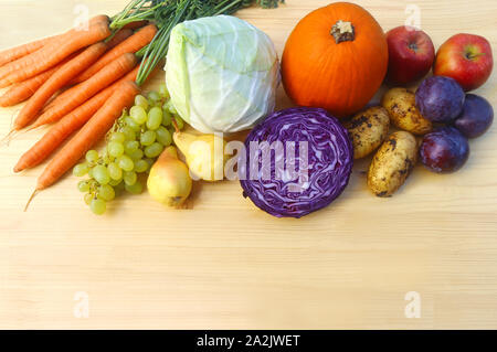 Table en bois clair avec une variété de légumes et fruits d'automne Banque D'Images