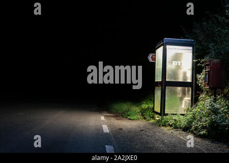 Un téléphone public fort le long d'une route de campagne au milieu de la nuit. , Cumbria (Royaume-Uni). Banque D'Images