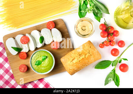 La cuisine italienne et le vin. Fromage Mozzarella, pain ciabatta, basilic, pesto. La cuisine de l'Italie sur un fond blanc Banque D'Images