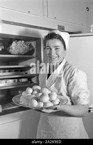 Eine Köchin mit frischen Eiern in der Küche und Gaststätte, Deutschland 1930 er Jahre. Une femme avec des oeufs frais à la cuisine d'un restaurant, l'Allemagne des années 1930. Banque D'Images