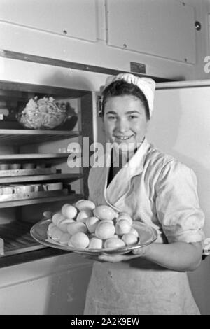 Eine Köchin mit frischen Eiern in der Küche und Gaststätte, Deutschland 1930 er Jahre. Une femme avec des oeufs frais à la cuisine d'un restaurant, l'Allemagne des années 1930. Banque D'Images