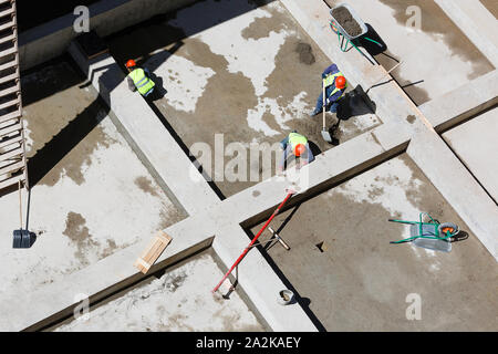 Les travailleurs en uniforme sable propre sur un site de construction, vue d'en haut. Banque D'Images