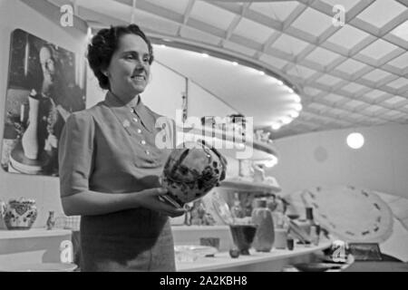 Eine Frau präsentiert auf dem Messestand feines Porzellan au der Messe Leipzig, Deutschland 1940 er Jahre. Une femme présentant la porcelaine fine sur le stand au salon de Leipzig, Allemagne 1940. Banque D'Images