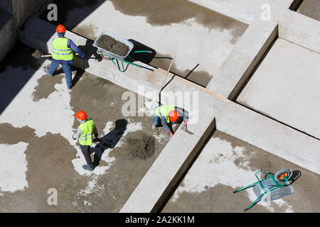 Les travailleurs en uniforme sable propre sur un site de construction, vue d'en haut. Banque D'Images